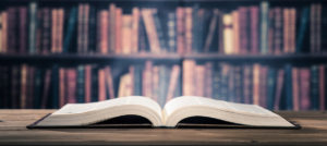 Open book on desk with library in background